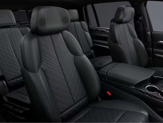 The interior of a luxury SUV features black quilted leather seats with diamond-pattern stitching