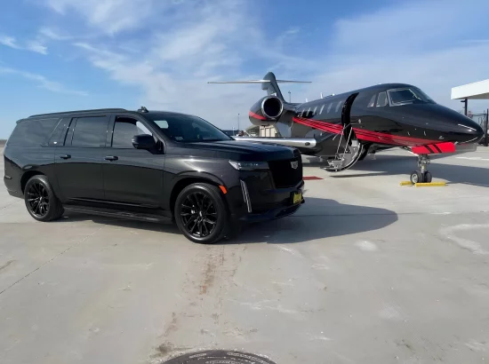 Luxury black Cadillac Escalade at airport with a luxury private jet